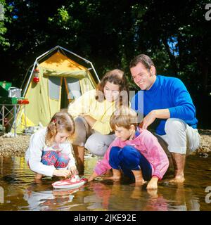 1970S FAMIGLIA CHE GIOCA IN STREAM MADRE PADRE FIGLIO FIGLIA CON TENDA E CAMPEGGIO IN BACKGROUND - KC4549 HAR001 HARS DAD CAMP FOUR MOM ABBIGLIAMENTO NOSTALGICO COPPIA 4 COLORE MADRI VECCHIO TEMPO NOSTALGIA FRATELLO VECCHIO MODO SORELLA 1 GIOVANE STILE LAVORO DI SQUADRA VACANZE FIGLI COMPIACENTI FAMIGLIE GIOIA LIFESTYLE SODDISFAZIONE FEMMINE SPOSATI CONIUGI RURALE CONIUGE MARITI SALUBRITÀ COPIA SPAZIO AMICIZIA MEZZA LUNGHEZZA SIGNORE FIGLIE PERSONE RUSCELLO CURA MASCHI ACCAMPAMENTO FRATELLI GREZZI SORELLE PADRI PARTNER LIBERTÀ TEMPO OFF FELICITÀ ALTA ANGOLO AVVENTURA VIAGGIO DI PIACERE E. VACANZA BREVE DADS RICREAZIONE ORGOGLIO VACANZE Foto Stock