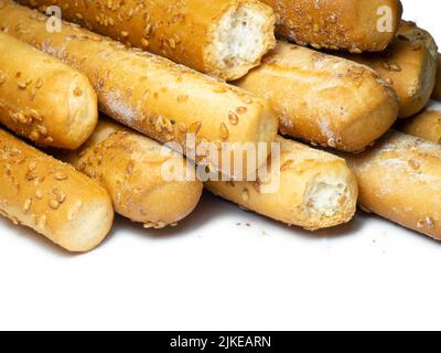 Biscotti al sesamo su sfondo bianco. I biscotti sono allungati sotto forma di bastoncini. Prodotti del pane. Prodotti a base di farina per spuntini. Un sacco di torte fatte in casa Foto Stock