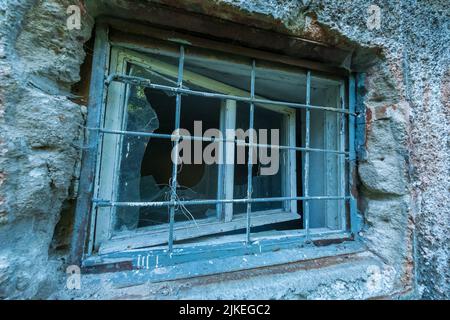 Griglia sulla finestra di edificio abbandonato Foto Stock