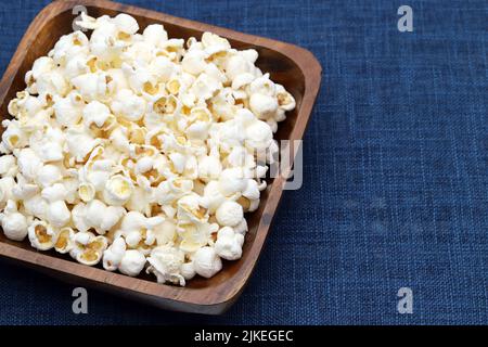 Popcorn in ciotola di legno sul tavolo, vista laterale, primo piano Foto Stock