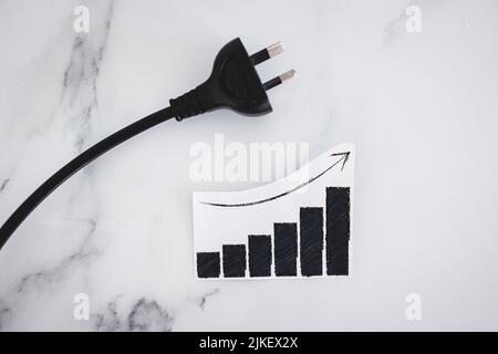 i costi dell'elettricità saliscono, immagine concettuale con plug nxt per il grafico delle statistiche che mostra i prezzi salendo Foto Stock