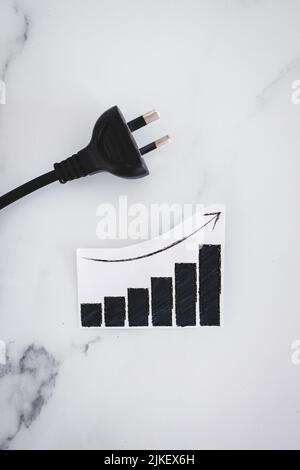 i costi dell'elettricità saliscono, immagine concettuale con plug nxt per il grafico delle statistiche che mostra i prezzi salendo Foto Stock