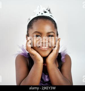 Non dimenticate mai la vostra corona. Una bambina che indossa un costume da principessa su sfondo bianco. Foto Stock