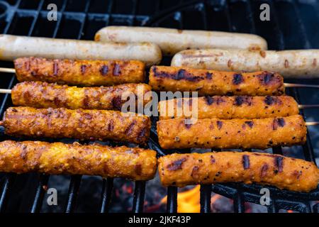 salsicce vegane e spiedini vegani su una griglia a carbone Foto Stock