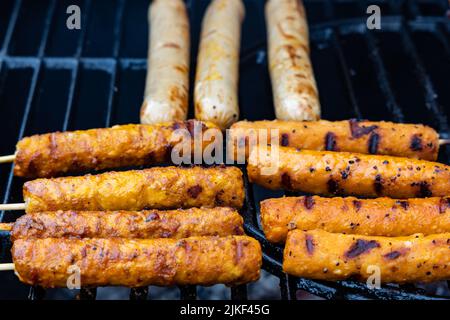 salsicce vegane e spiedini vegani su una griglia a carbone Foto Stock