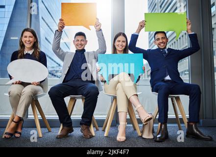 Erano un team molto diversificato, un gruppo di giovani uomini d'affari che tenevano bolle d'espressione mentre aspettavano in fila. Foto Stock
