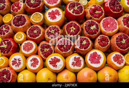Arancio, pompelmo, melograno tagliati a fette sono venduti sul banco di un negozio di frutta in via Istanbul. Sfondo di frutta. Foto Stock