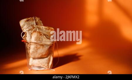 Bicchiere di plastica pieno con bustine di tè usate. Spazio di copia. Primo piano Foto Stock