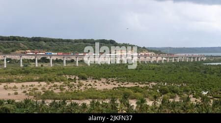 (220802) -- NAIROBI, 2 agosto 2022 (Xinhua) -- un treno merci corre sulla ferrovia di Mombasa-Nairobi, aggirando le mangrovie a Mombasa, Kenya, il 27 luglio 2022. La ferrovia cinese a scartamento standard Mombasa-Nairobi (SGR) ha appena festeggiato il suo quinto anniversario di funzionamento sicuro. La ferrovia di Mombasa-Nairobi attraversa riserve naturali come il Parco Nazionale di Nairobi e il Parco Nazionale di Tsavo. Al fine di ridurre l'impatto sull'ambiente, durante la progettazione e la costruzione della ferrovia sono state adottate una serie di misure, come ad esempio l'aggiramento delle mangrovie, che aiutano a mantenere l'uomo Foto Stock