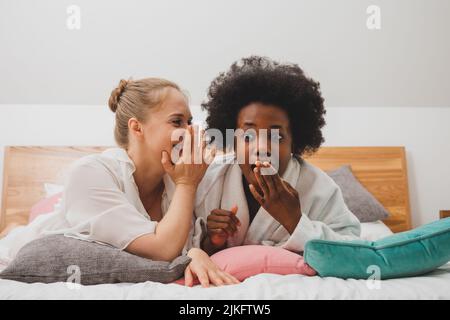 I migliori amici si rilassano al centro benessere e discutono dei segreti Foto Stock