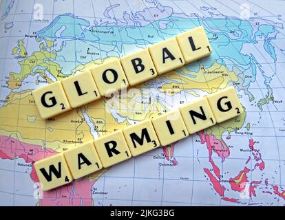 Cambiamento climatico , riscaldamento globale scritto in lettere Scrabble su una mappa Foto Stock