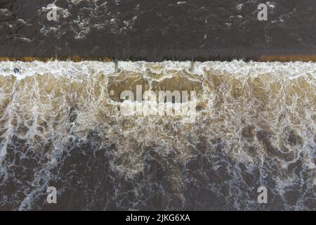 Kendal, Cumbria, Inghilterra, agosto 2nd 2022. - I livelli del fiume sono saliti a oltre 2 metri sul fiume Kent a Kendal, Cumbria con un torrente infuria di acqua che scorre attraverso la città. La pioggia pesante ha colpito la regione durante la notte con livelli di fiume che salgono a 2,033m o appena oltre sei piedi e mezzo il martedì 2 agosto 2022. Kendal è stato gravemente allagato nel 2015 durante la tempesta Desmond. Nelle ultime settimane è stata installata una nuova passerella in acciaio, 7 anni dopo che il ponte originale Gooseholme fu danneggiato nella tempesta del 2015. Credit: Michael Scott/Alamy Live News Foto Stock