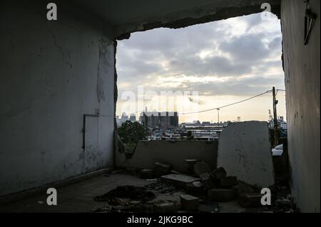 Beirut, Libano, 31 luglio 2022. Dopo aver fermentato il grano catturato fuoco e bruciato per oltre due settimane all'interno di silos di grano danneggiato nel 4 agosto 2020 Beirut Port Blast, due silos dal blocco nord della struttura crollò. Visto qui attraverso le macerie di un edificio danneggiato dall'esplosione che è rimasto intatto per due anni. Foto Stock