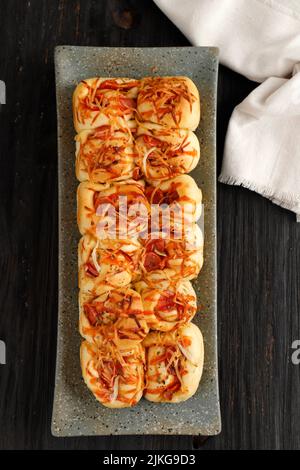 Vista dall'alto Pizza Sausage Roll tirare a parte il pane, su tavola di legno Foto Stock