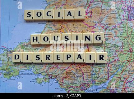 Welsh SocialHousing / Consiglio problemi di riparazione alloggi con riparazioni reattive scritto in lettere Scrabble su una mappa del Galles del Sud Foto Stock