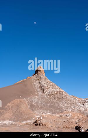 Luna su formazioni di pietra argillosa arrugginita nella Valle della Luna o Valle de Luna, San Pedro de Atacama, Cile. Foto Stock