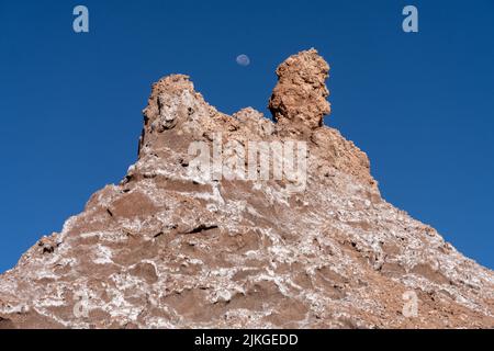 Luna su formazioni di pietra argillosa arrugginita nella Valle della Luna o Valle de Luna, San Pedro de Atacama, Cile. Foto Stock