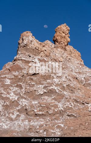 Luna su formazioni di pietra argillosa arrugginita nella Valle della Luna o Valle de Luna, San Pedro de Atacama, Cile. Foto Stock