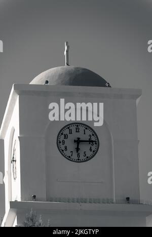 Una foto in scala di grigi di una torre dell'orologio a Oia, Santorini, Grecia Foto Stock