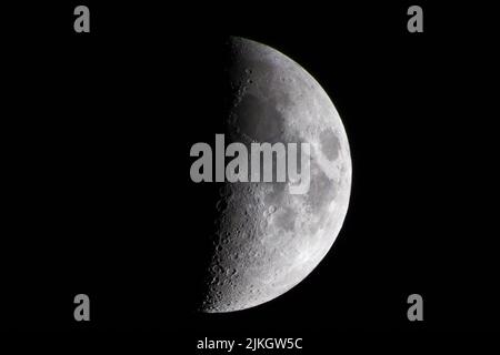 Primo piano di una mezza luna che illumina il cielo notturno scuro Foto Stock