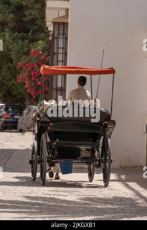 ronda,malaga,spagna 20 giugno 2022 Vista posteriore dei turisti in una carrozza trainata da cavalli che visitano la città. Foto Stock