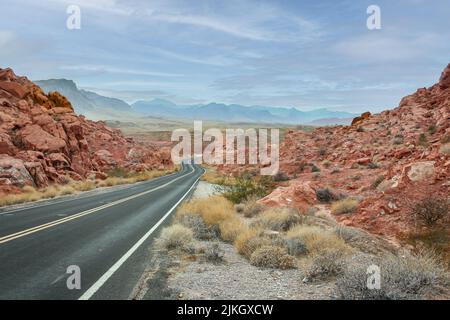 Autostrada a due vie vuota che conduce alla Valle del fuoco circondata da rocce di arenaria Foto Stock