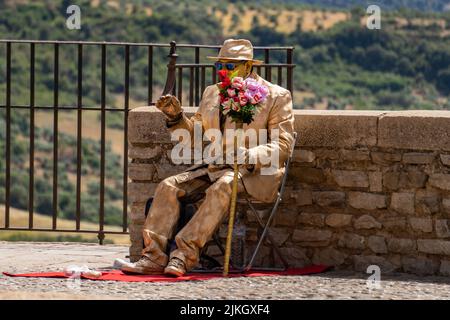 ronda,malaga,spagna 20 giugno 2022 artista di strada in abbigliamento color oro che si esibisce in un parco Foto Stock