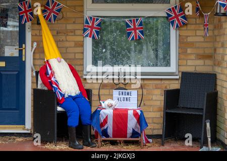 scarecrow vestito come gnome che tiene la bandiera di Union jack in celebrazione del Giubileo di platino della Regina e segno solo gnome Foto Stock