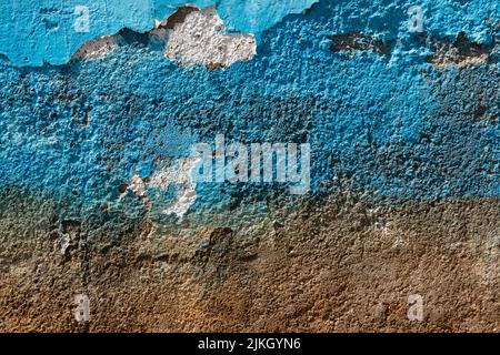 Un primo piano di una parete di cemento in parte dipinta di blu Foto Stock