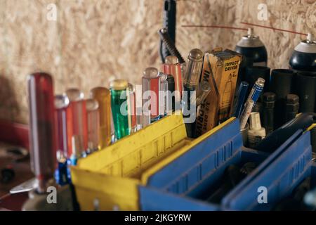 Gli attrezzi meccanici su un ripiano vicino ad una parete di legno Foto Stock