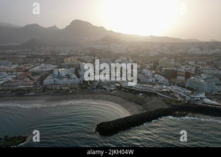 La vista aerea della Costa Adeje a Tenerife Spagna in una giornata polverosa all'alba con le montagne Foto Stock