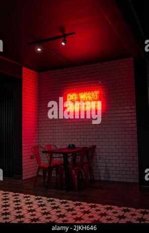 Uno scatto verticale del segno 'fate che cosa amate' in un piccolo ristorante a la Serena, Cile Foto Stock