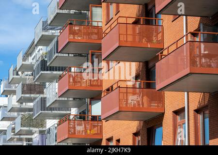 Particolare di edifici di appartamenti rossi e bianchi con molti balconi visti a Berlino, Germania Foto Stock