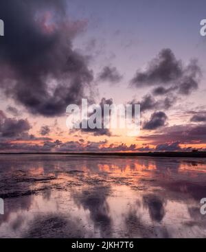 una bella vista del cielo nuvoloso tramonto sul mare Foto Stock