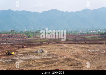 Un terreno roccioso in discesa sullo sfondo di montagne boschive Foto Stock