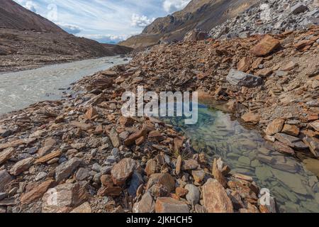 Laghetto cristallino, in mezzo a morene vicino a un torbido torrente glaciale Foto Stock