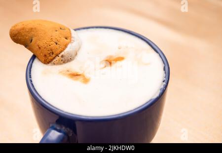 biscotti con pezzi di cioccolato in una tazza di cappuccino Foto Stock