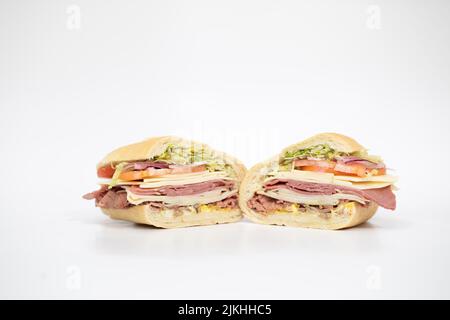 Un panino italiano affettato a metà raffigurante tutti i suoi ingredienti su sfondo bianco Foto Stock