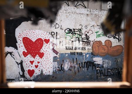 Vista di un muro al confine tra Israele e Palestina dal lato palestinese con graffiti Foto Stock