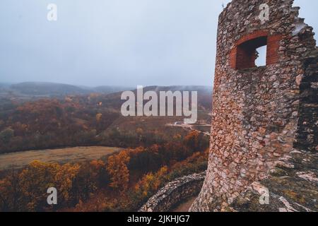 Una bella foto delle rovine del castello di Csesznek in Ungheria in una giornata di nebbia Foto Stock