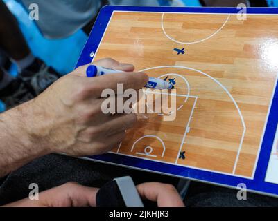 La mano di una persona con un marcatore che prende appunti su una tavola da campo di calcio - concetto di strategia di gioco Foto Stock