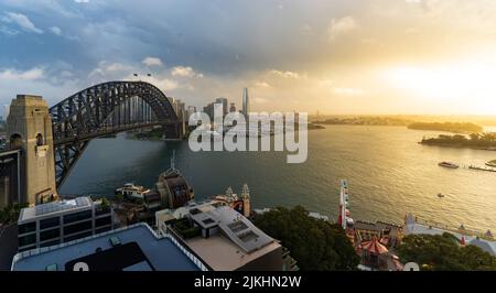 Un'immagine aerea del famoso Sydney Harbor Bridge durante il tramonto con le nuvole che lo sovrastano Foto Stock