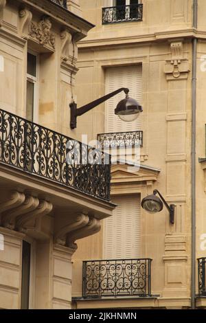 Un primo piano verticale della facciata dell'edificio in stile francese con balconi a Parigi, Francia Foto Stock