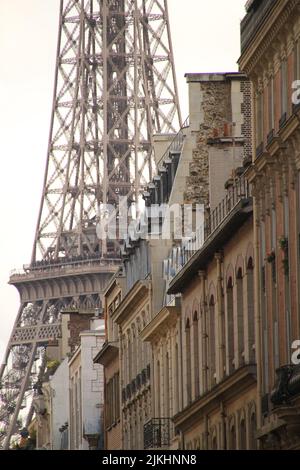 Uno scatto verticale della parte della Torre Eiffel e delle facciate degli edifici a Parigi, Francia Foto Stock