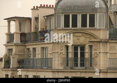 Un primo piano della facciata di un edificio in stile francese con balconi a Parigi, Francia Foto Stock