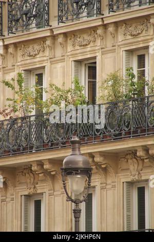 Un primo piano verticale della facciata dell'edificio in stile francese con balconi a Parigi, Francia Foto Stock