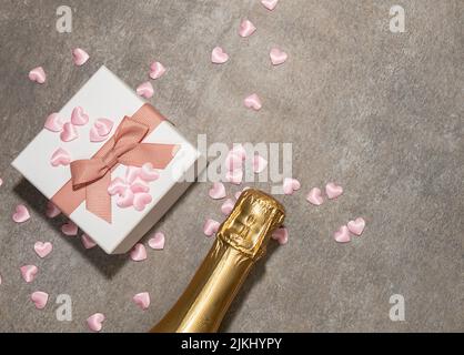 San Valentino sfondo con cuori, confezione regalo, champagne. Sullo sfondo della tavola in pietra grigia, vista dall'alto Foto Stock