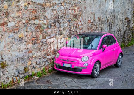Italia, Toscana, Siena. Un'auto di colore rosa, fiat 500, in stile italiano Foto Stock