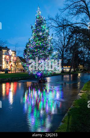 L'albero di Natale nel fiume a Bourton-on-the-Water nei Cotswolds. Foto Stock