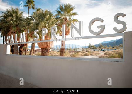 Una foto di Palm Springs segno nel deserto con palme Foto Stock